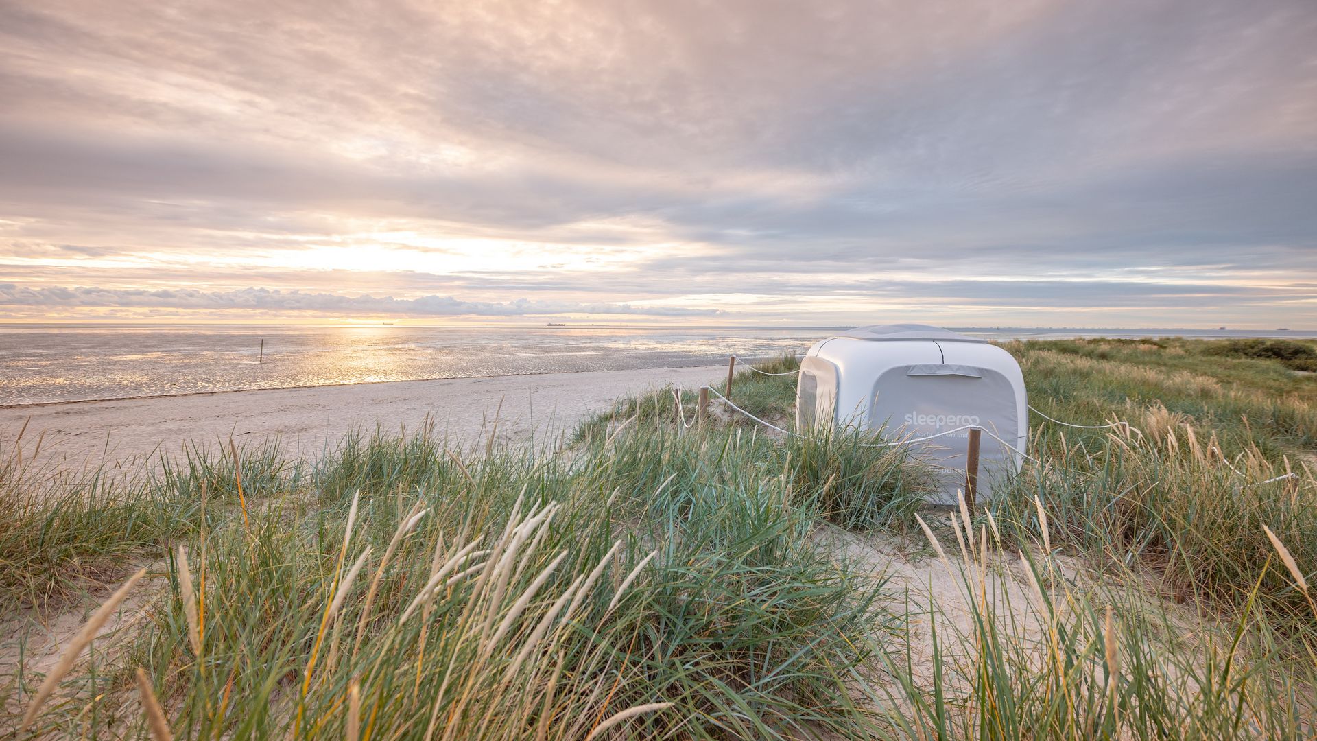 Sleeperoo Cube zum übernachten in den Dünen von Schillig bei Sonnenuntergang